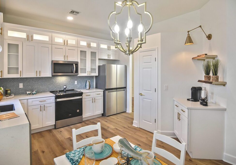 Modern kitchen with white cabinets and stainless steel appliances.