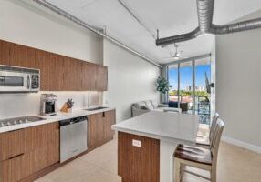 Modern kitchen with wooden cabinetry and island seating.