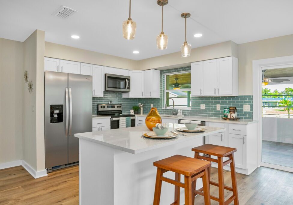 Modern kitchen with white cabinetry and island seating.