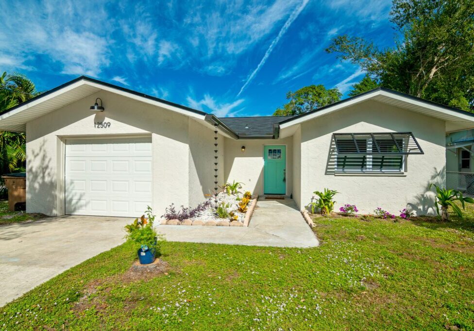 Sunny front yard with a cozy house and clear blue sky.