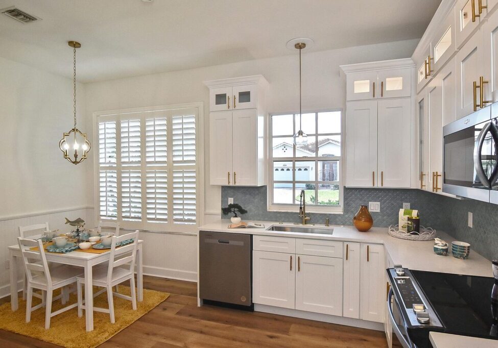 Bright kitchen with white cabinets, stainless steel appliances, and a cozy dining area.